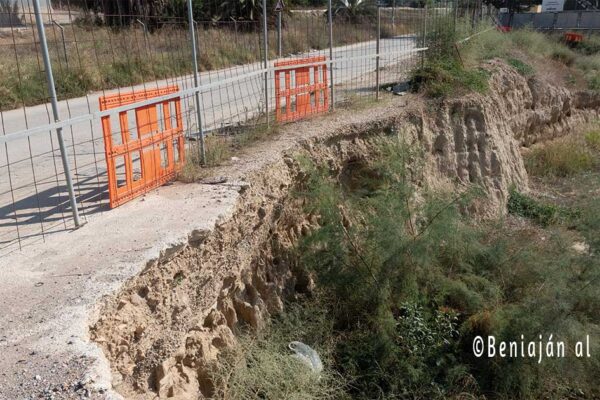 Vista del socavón en un tramo de la acera del Bojar en Beniaján, junto a la obra paralizada, donde se aprecia el riesgo de desprendimiento de tierra y el estrechamiento del paso peatonal.