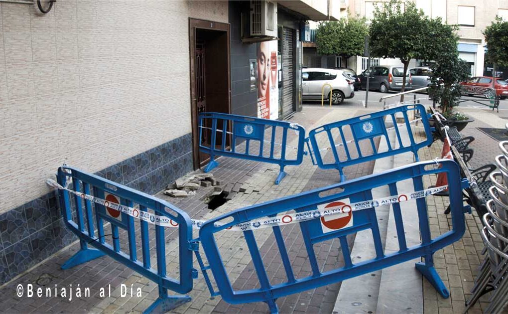 Socavón de grandes dimensiones en la Calle Ánimas de Beniaján, con la zona acordonada por vallas perimetrales de la Policía Local de Murcia.