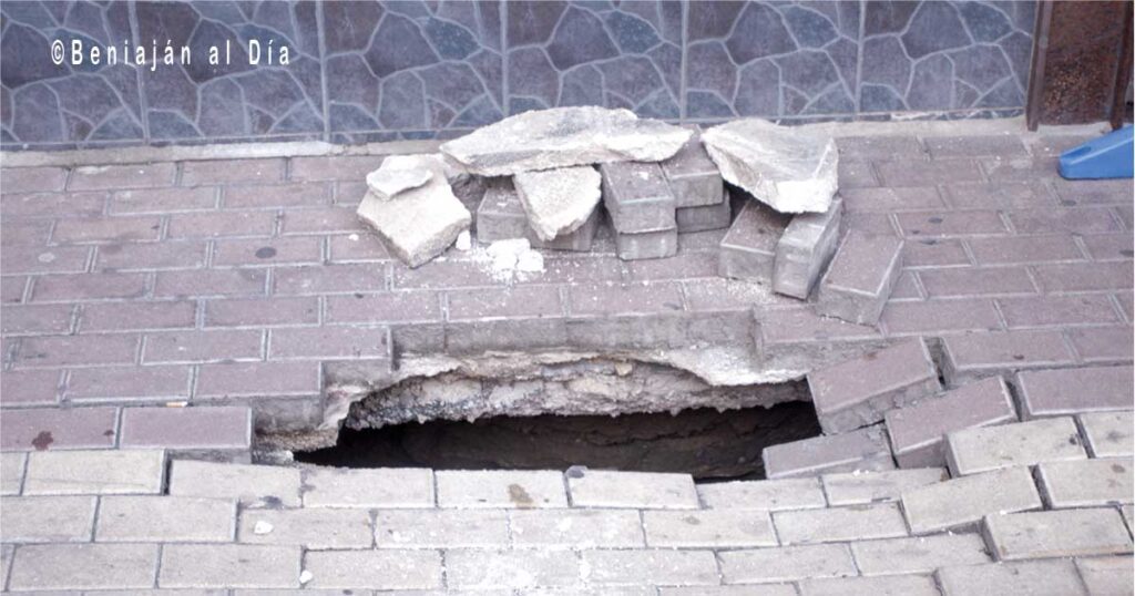 Socavón en Calle Ánimas de Beniaján, con el pavimento hundido y un boquete visible en primer plano.