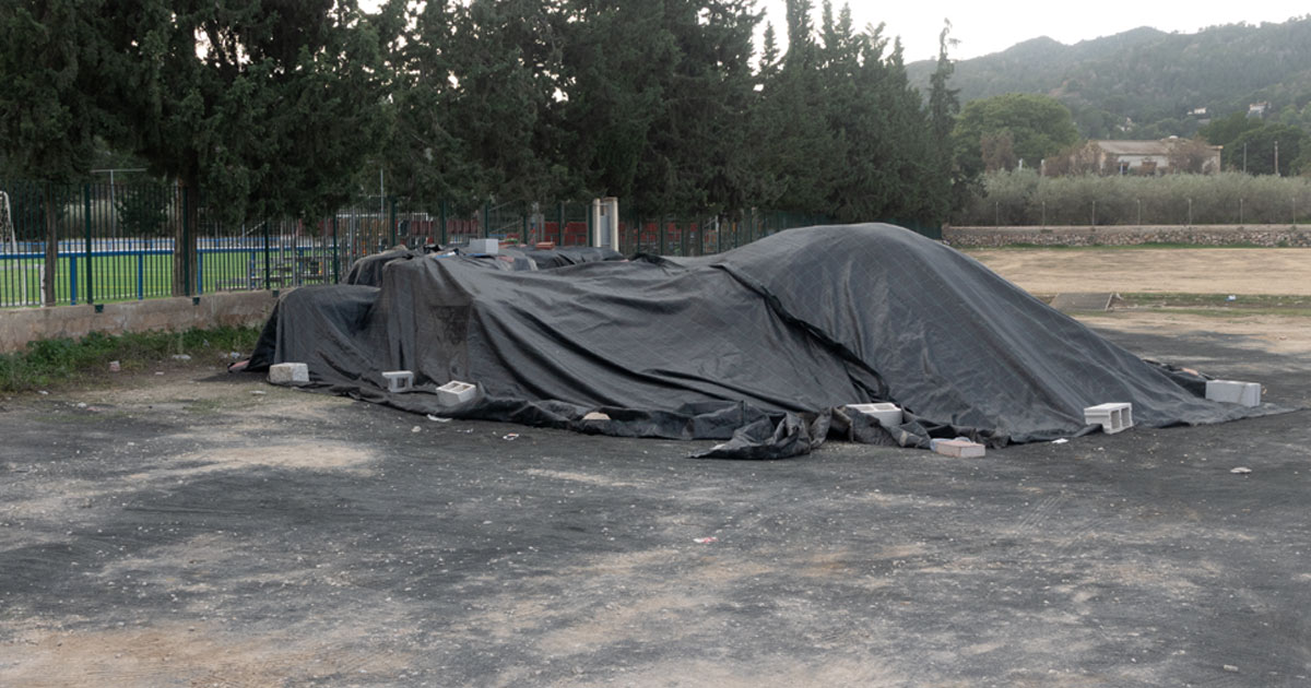 Residuos señalados por el grupo socialista en las instalaciones del campo de fútbol de Beniaján, cubiertos con lonas