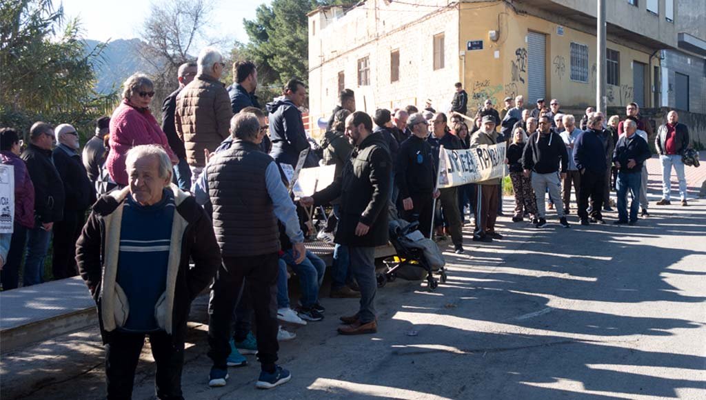 Manifestantes con pancartas y lemas durante la concentración por la limpieza de la rambla del Garruchal en El Secano.