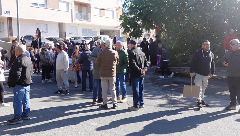 Manifestantes con pancartas participando activamente en la concentración por la limpieza de la rambla del Garruchal en El Secano.