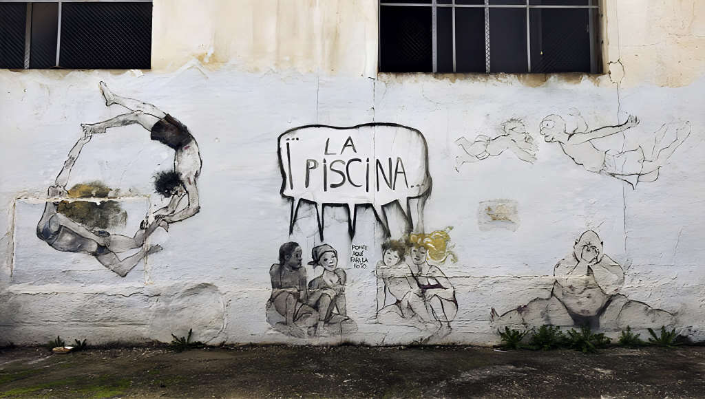 Detalle del mural de Chipola en Beniaján mostrando niños en bañador jugando y nadando en una piscina imaginaria, con la viñeta central que proclama “¡La Piscina!”, reflejando la reivindicación histórica de la pedanía.