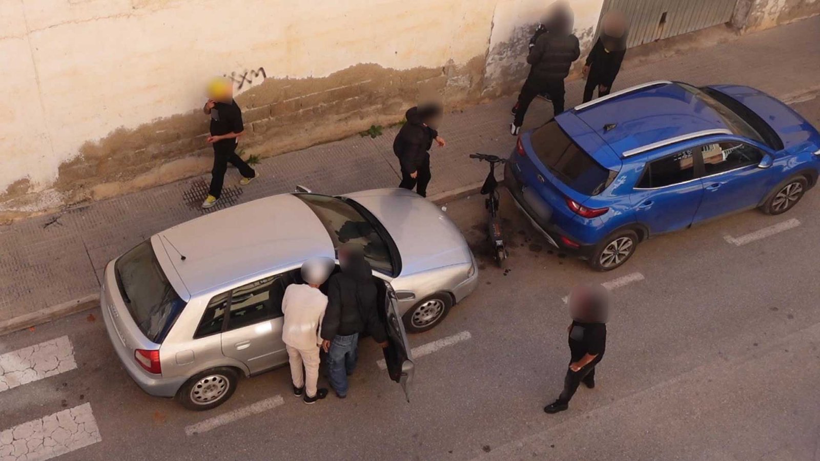 Reyerta en la calle Instituto de Beniaján, con un grupo de individuos agrediendo a un conductor dentro de su vehículo.