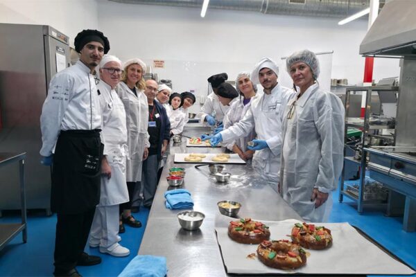 Alumnos de la Escuela de Hostelería Murcia Emplea preparando roscones de Reyes artesanales para el taller infantil en la Plaza Circular.