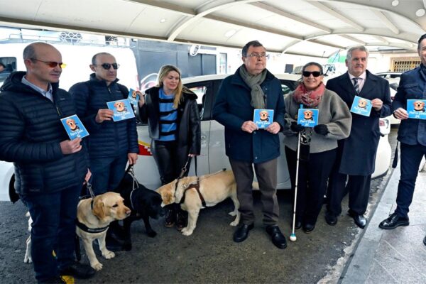 Alcalde de Murcia José Ballesta junto a varias personas ciegas con sus perros guía durante la presentación de la campaña de taxis accesibles en la Plaza Cetina.