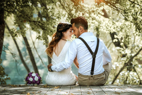 Pareja de enamorados sentados de espaldas con la cabeza apoyada y un ramo de flores en San Valentín en Beniaján.