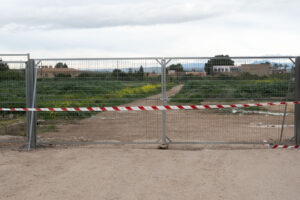 Vallado de los terrenos junto al CEIP Nuestra Señora de la Fuensanta con cinta de advertencia blanca y roja.