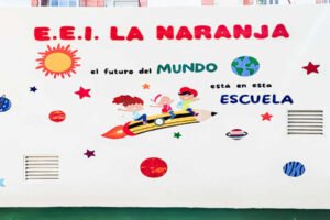 Lona decorativa de la Escuela Infantil La Naranja de Beniaján con dibujos infantiles y el nombre del centro.