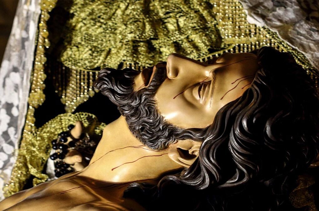 Rostro de Jesucristo en el cartel de la Semana Santa 2026 de Beniaján, representado en brazos de la Virgen María tras descender de la cruz.