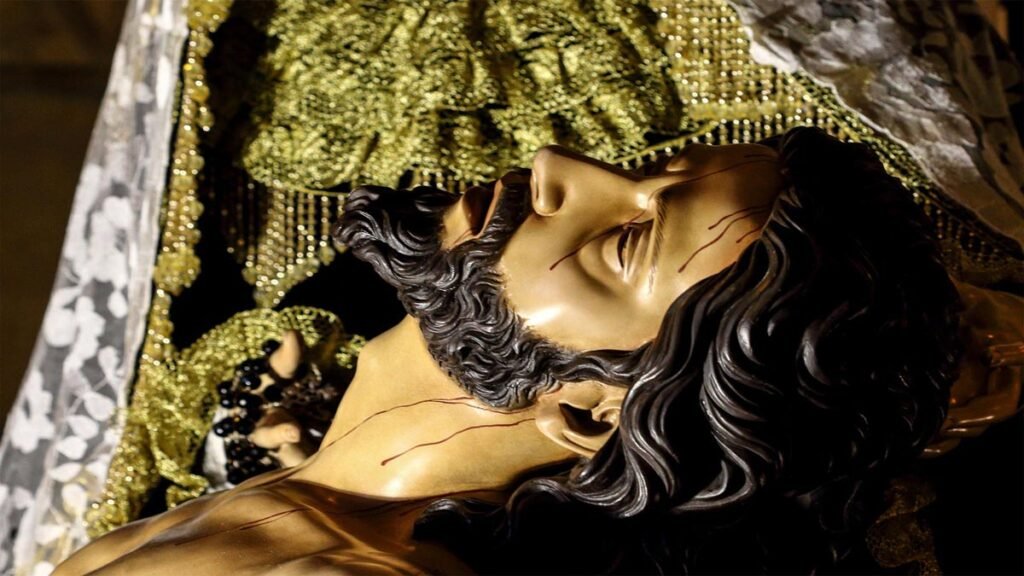 Rostro de Jesucristo en el cartel de la Semana Santa 2026 de Beniaján, representado en brazos de la Virgen María tras descender de la cruz.