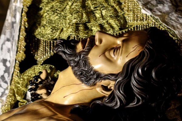 Rostro de Jesucristo en el cartel de la Semana Santa 2026 de Beniaján, representado en brazos de la Virgen María tras descender de la cruz.