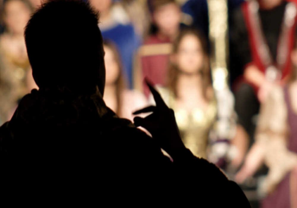 Masterclass de Técnica Vocal con Alfonso Serra en Beniaján. Silueta del director frente al coro y auditorio del Centro Cultural de Beniaján, 22 de abril de 2026.
