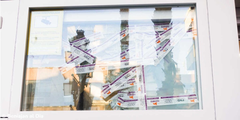 Ventana de La Heladería en Beniaján con cristales rotos sujetos con cinta tras un intento de robo.