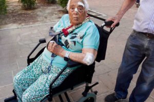 Manoli, vecina de Beniaján, en silla de ruedas tras sufrir una caída provocada por el mal estado de una acera junto al jardín del Superdumbo