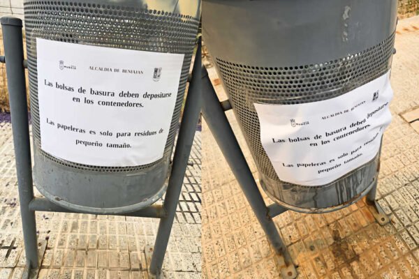 Papeleras con cartel de aviso de la campaña del alcalde de Beniaján sobre el uso correcto de las papeleras