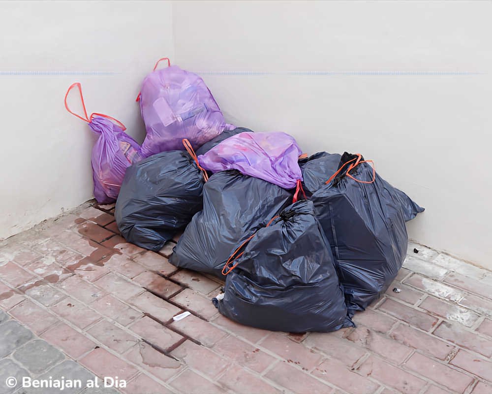 Bolsas de basura depositadas fuera del contenedor en una acera de Beniaján (Murcia)
