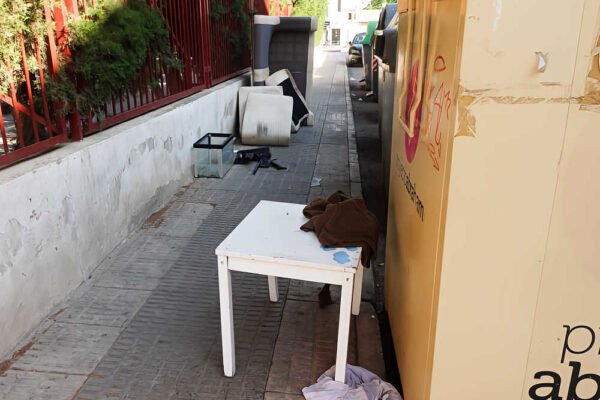 Muebles, colchones y otros enseres abandonados junto a una acera en Beniaján, Murcia.