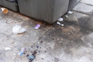 Contenedores de basura insalubres en Beniaján, Murcia, con residuos y suciedad acumulada en el suelo