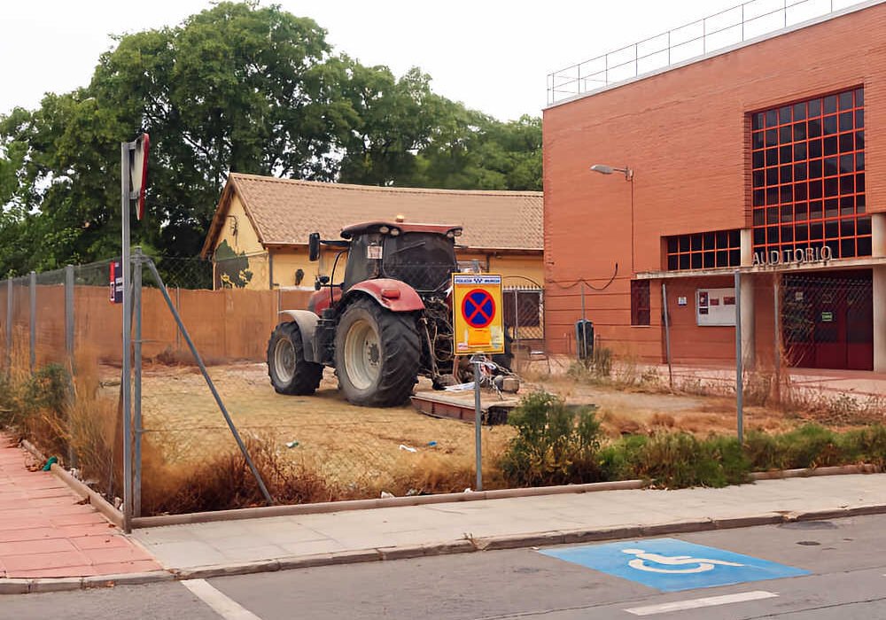 Solar de la calle Antonia Maymón de Beniaján durante los trabajos de limpieza y desbroce, con un tractor en el interior.