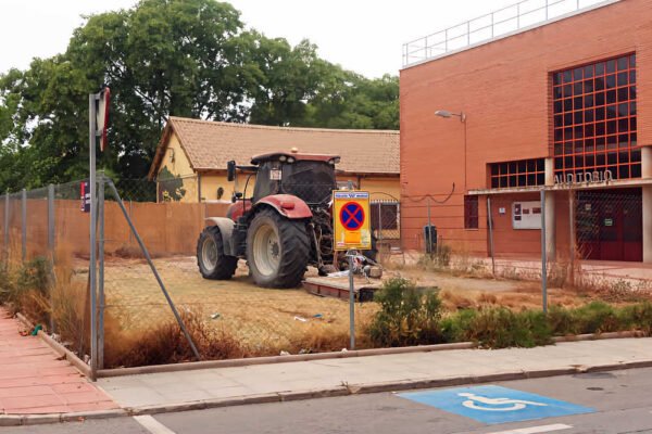 Solar de la calle Antonia Maymón de Beniaján durante los trabajos de limpieza y desbroce, con un tractor en el interior.