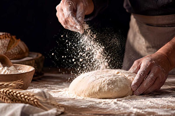 Elaboración artesanal de pan con harina durante el Día del Pan en Beniaján