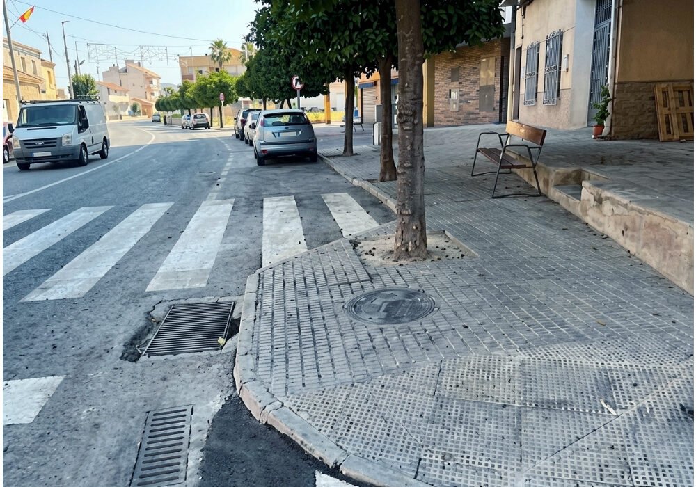 Paso de peatones y acera con bordillo no accesible en el cruce de la Avenida de Murcia con la Calle Caridad en Los Ramos, Murcia.