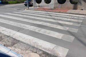 Paso de peatones inaccesible en San José de la Vega (Murcia) con bordillo vertical y calzada deteriorada sin rebaje a cota cero.